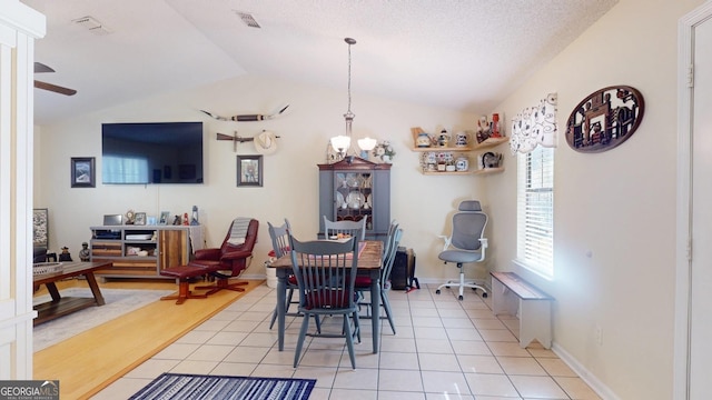 dining area with light tile patterned floors, visible vents, a ceiling fan, and lofted ceiling