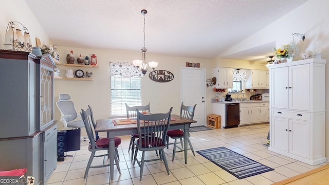 dining area with lofted ceiling, a textured ceiling, an inviting chandelier, and light tile patterned flooring