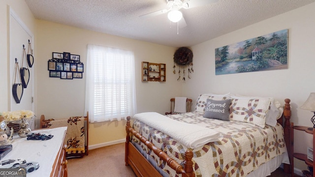 bedroom featuring baseboards, light colored carpet, a textured ceiling, and a ceiling fan