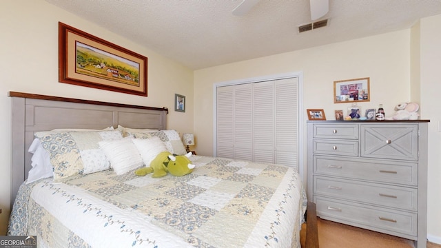 bedroom with a closet, visible vents, a textured ceiling, and a ceiling fan