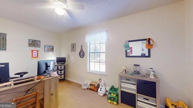 office area featuring baseboards, light carpet, a textured ceiling, and ceiling fan