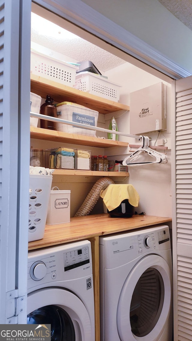 washroom featuring washer and clothes dryer, laundry area, and a textured ceiling