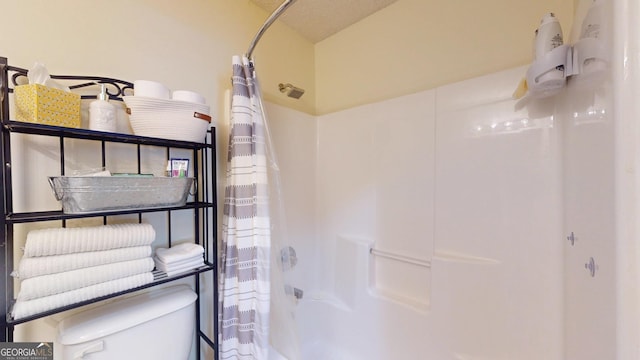 bathroom featuring shower / bath combo with shower curtain and toilet