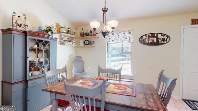 dining space with a textured ceiling, a chandelier, and light tile patterned flooring