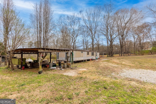 view of yard with a carport and an outbuilding