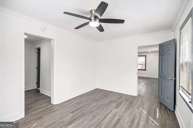 spare room featuring baseboards, crown molding, a ceiling fan, and wood finished floors