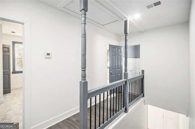 hallway with visible vents, baseboards, and wood finished floors