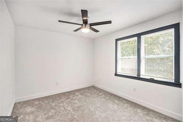 empty room with baseboards, ceiling fan, and carpet floors