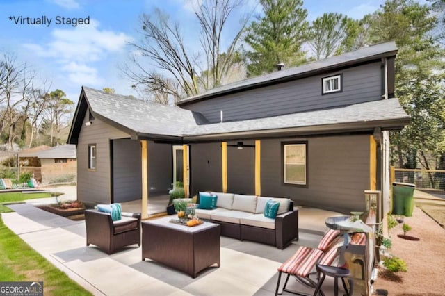 back of property featuring a patio area, outdoor lounge area, and a shingled roof