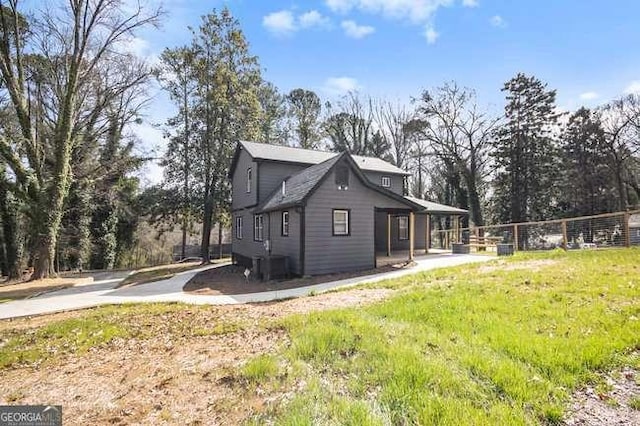 rear view of house with cooling unit and fence