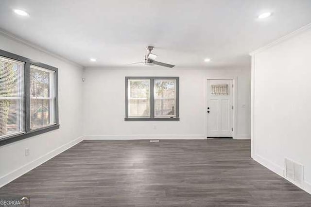 interior space with dark wood-style floors, baseboards, ceiling fan, and crown molding