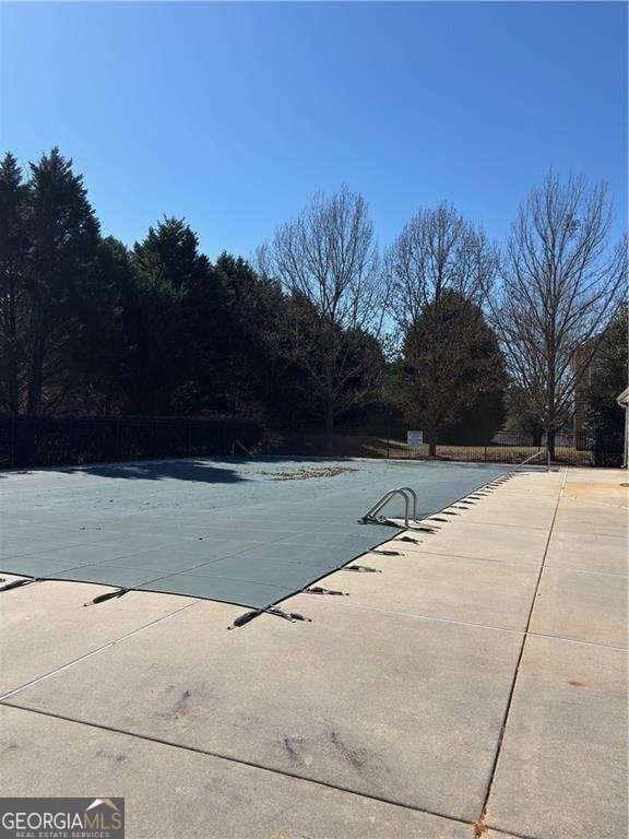 community pool featuring a patio and fence