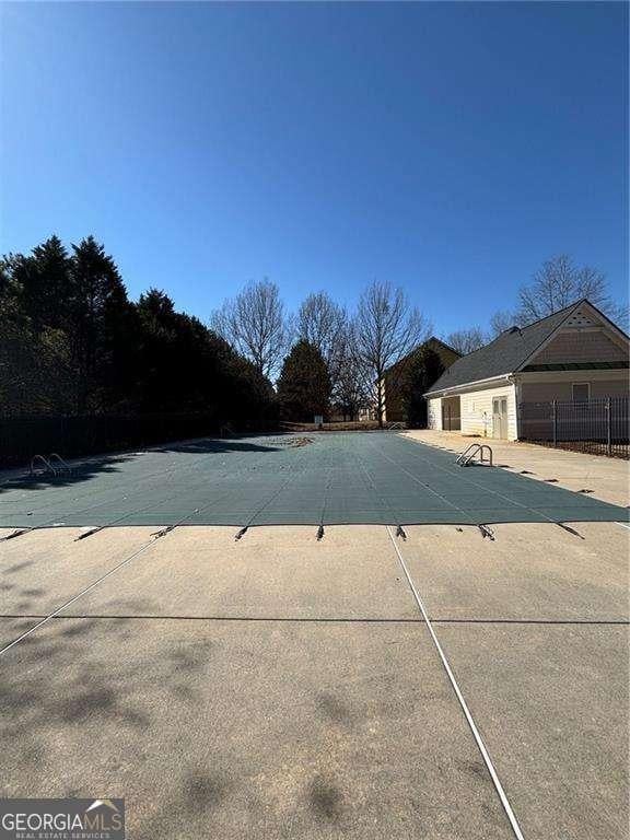 pool with a patio area and fence