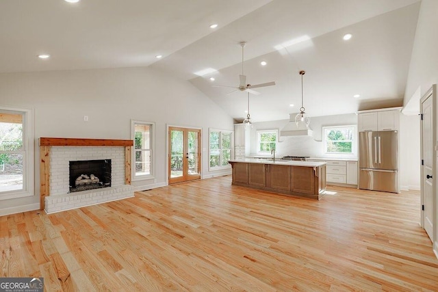 kitchen featuring open floor plan, light countertops, freestanding refrigerator, light wood-style floors, and a sink