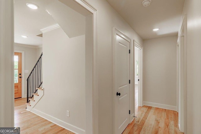 hallway featuring crown molding, recessed lighting, light wood-style floors, and baseboards