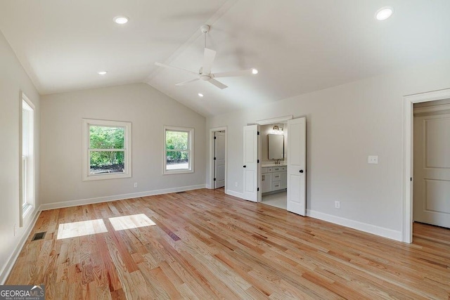 unfurnished bedroom featuring visible vents, lofted ceiling, light wood-style floors, and baseboards