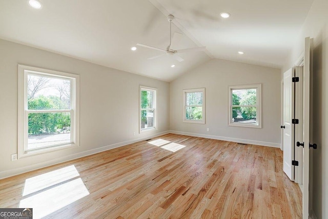 empty room with light wood-type flooring, lofted ceiling, baseboards, and a ceiling fan