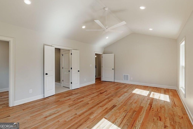 unfurnished bedroom featuring lofted ceiling, baseboards, visible vents, and light wood-type flooring