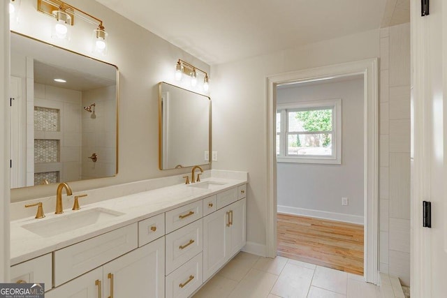 full bath featuring double vanity, tile patterned floors, a tile shower, and a sink