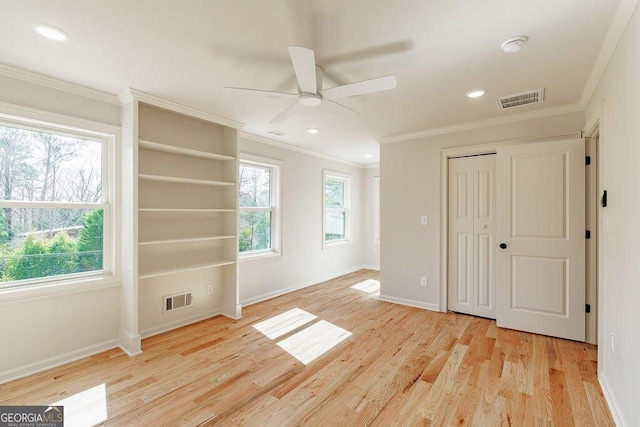 unfurnished bedroom with visible vents, light wood-style flooring, crown molding, and multiple windows