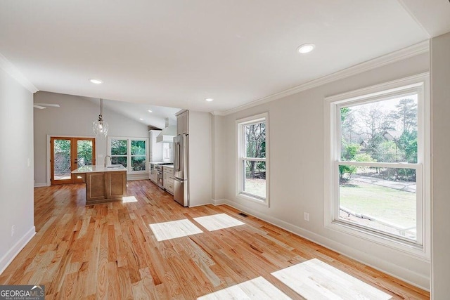 kitchen with light wood-style flooring, a sink, vaulted ceiling, light countertops, and high quality appliances