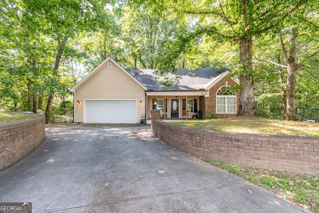 ranch-style house featuring concrete driveway, a porch, and a garage