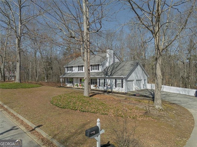 view of front of home featuring fence, a porch, a chimney, concrete driveway, and a garage