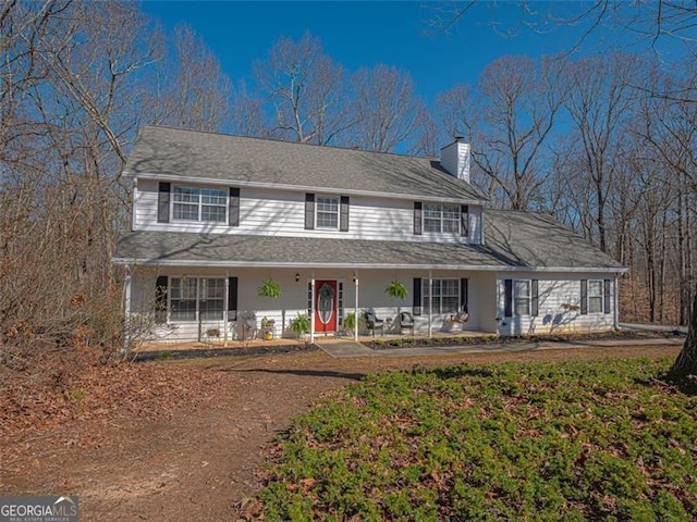 farmhouse featuring a porch and a chimney