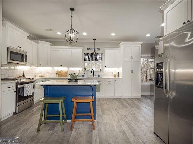 kitchen featuring a sink, stainless steel appliances, light countertops, and white cabinetry