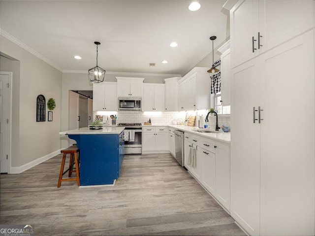 kitchen with tasteful backsplash, crown molding, a kitchen bar, appliances with stainless steel finishes, and a sink