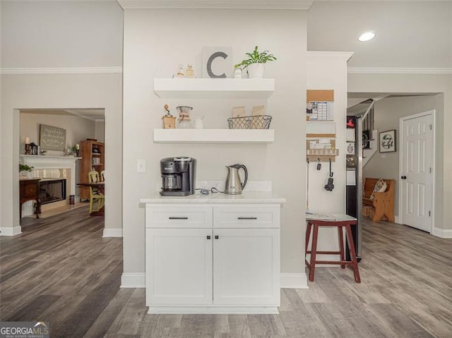 bar with crown molding, light wood-style floors, and baseboards