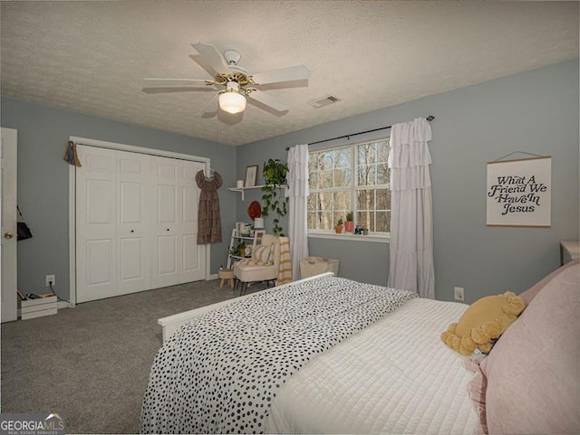 carpeted bedroom featuring visible vents, a textured ceiling, a closet, and ceiling fan