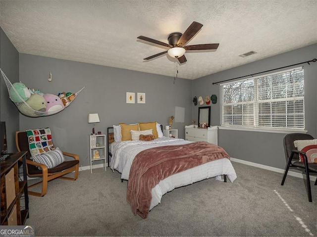 carpeted bedroom featuring visible vents, ceiling fan, a textured ceiling, and baseboards