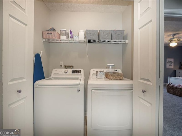 laundry room with washing machine and clothes dryer, laundry area, a textured ceiling, and carpet