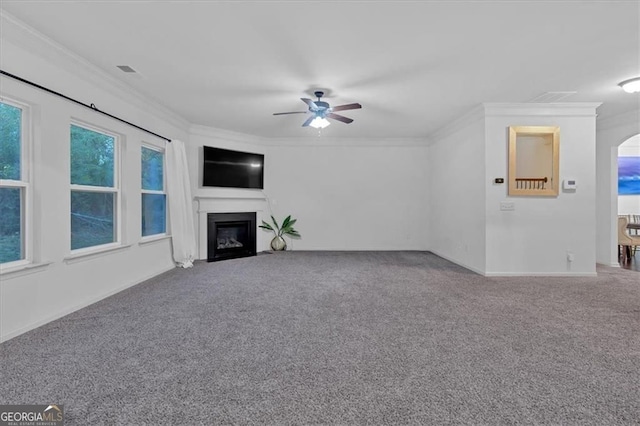 unfurnished living room featuring a ceiling fan, a fireplace with flush hearth, carpet, and ornamental molding