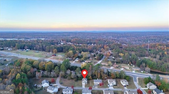 aerial view at dusk with a wooded view