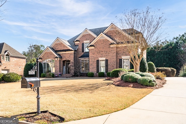 view of front facade with brick siding and a front lawn