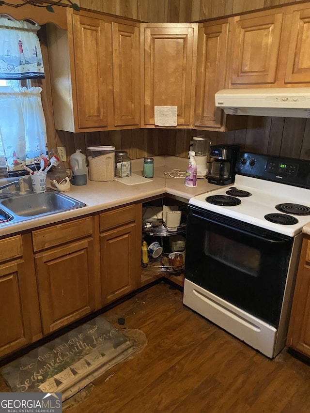 kitchen featuring dark wood finished floors, a sink, light countertops, electric stove, and under cabinet range hood