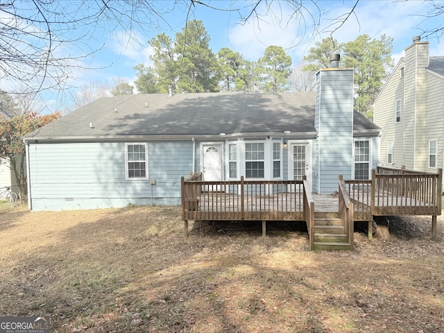 rear view of house with crawl space, a wooden deck, a chimney, and a shingled roof