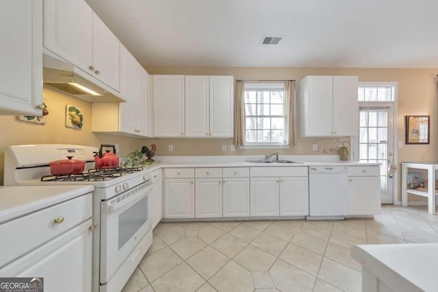 kitchen with a sink, visible vents, white appliances, and light countertops