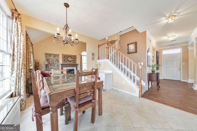 dining room featuring ornamental molding, light tile patterned floors, baseboards, a chandelier, and stairs