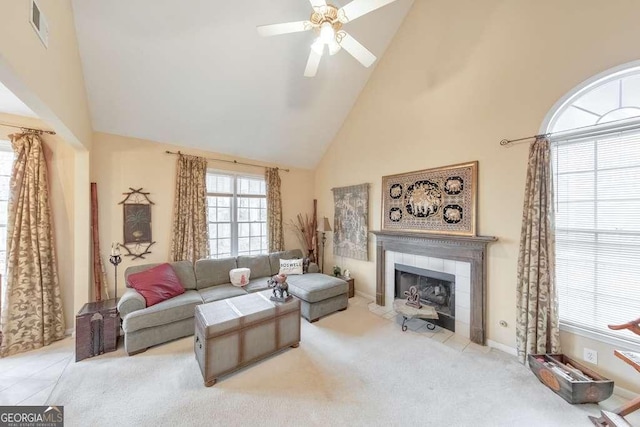 living area featuring visible vents, carpet flooring, a fireplace, high vaulted ceiling, and a ceiling fan