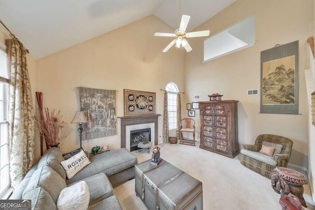 carpeted living room with high vaulted ceiling, a fireplace, visible vents, and ceiling fan