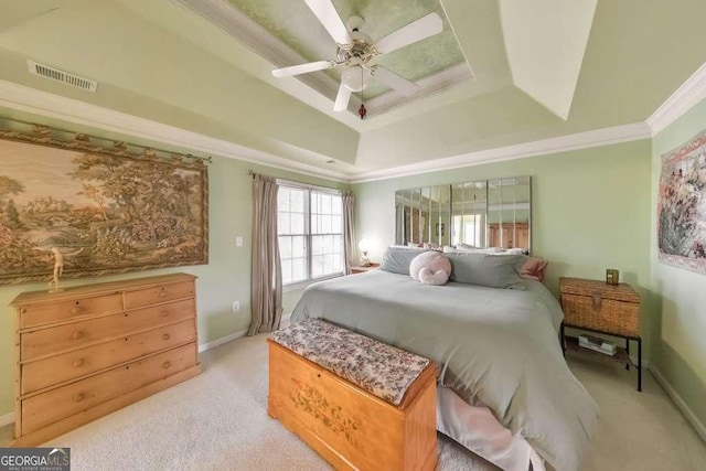 bedroom with a raised ceiling, baseboards, visible vents, and ornamental molding