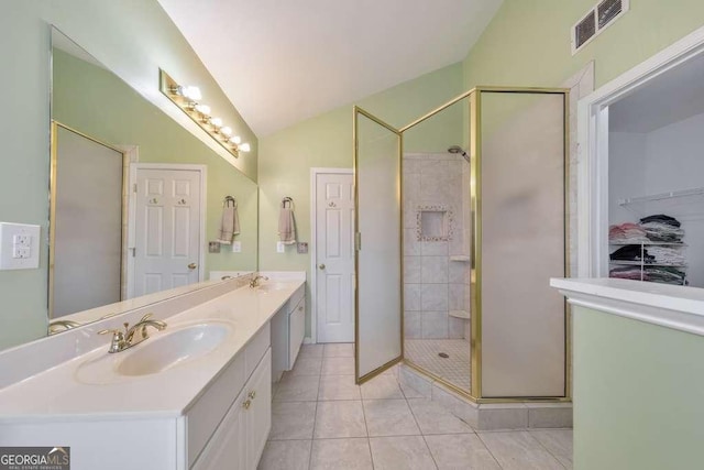 bathroom with lofted ceiling, visible vents, a shower stall, and a sink