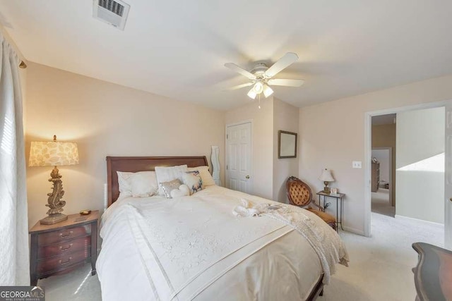 bedroom featuring visible vents, baseboards, ceiling fan, light colored carpet, and a closet