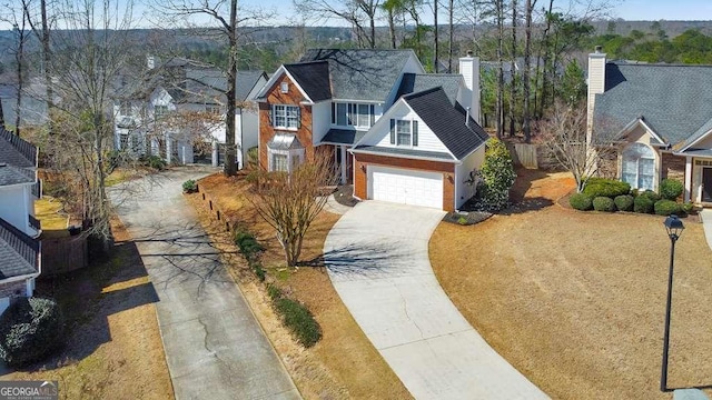 traditional-style home featuring a garage, a residential view, a chimney, and driveway