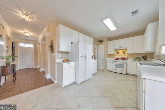 kitchen with white appliances, light countertops, visible vents, and a sink