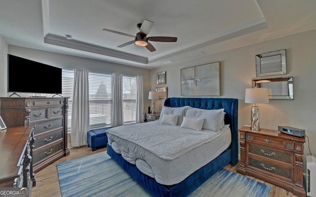 bedroom featuring visible vents, a tray ceiling, and wood finished floors