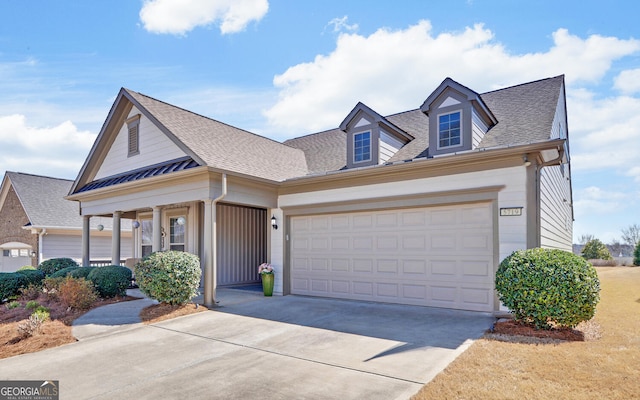 view of front facade featuring roof with shingles, concrete driveway, and an attached garage